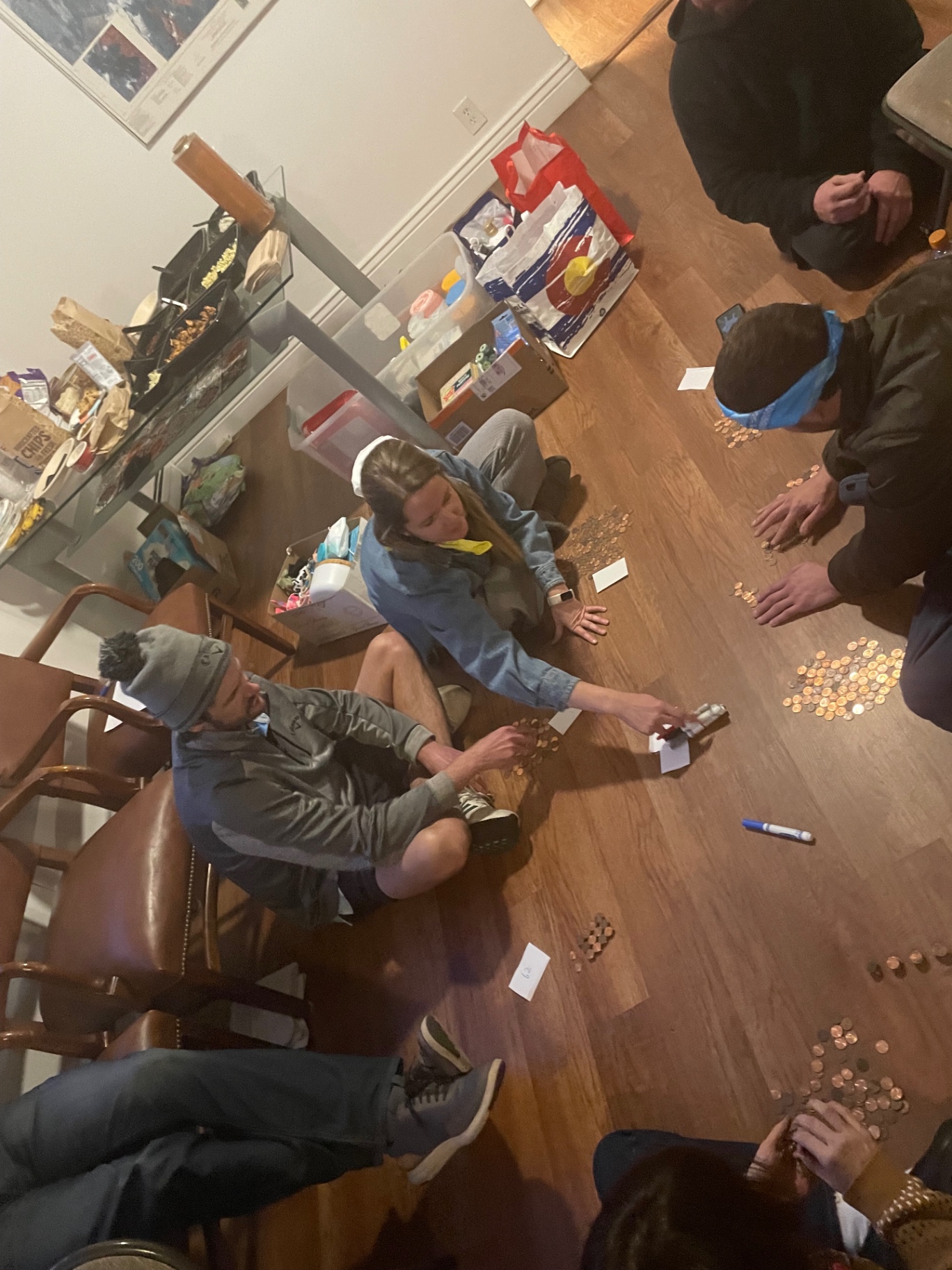 Volunteers in bandanas sorting piles of donated coins on the floor