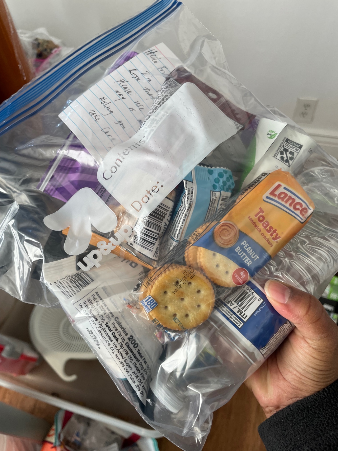 A finished care package with snacks, hygiene items and a handwritten note